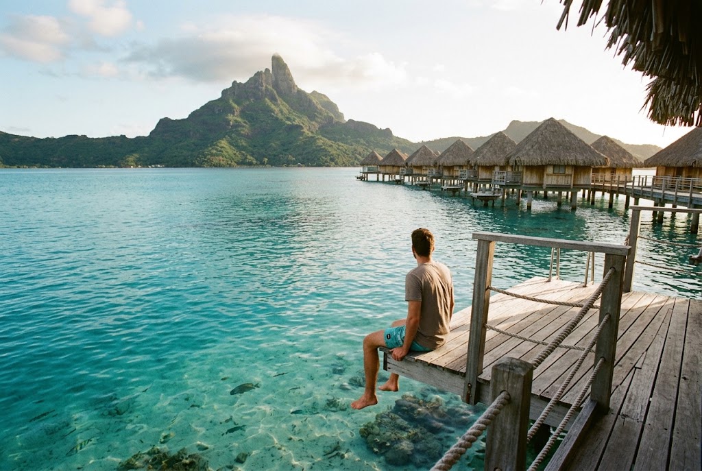 Overwater bungalows on a turquoise lagoon in Bora Bora, French Polynesia, one of the luxury travel destinations for $5000 to $10000